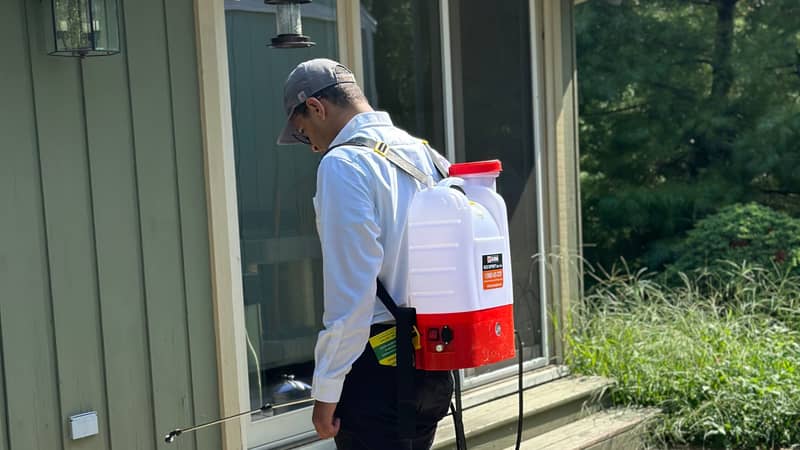 Technician treating the outside of a home